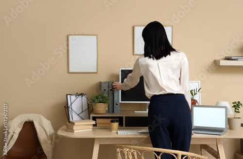 Young woman taking folder i...