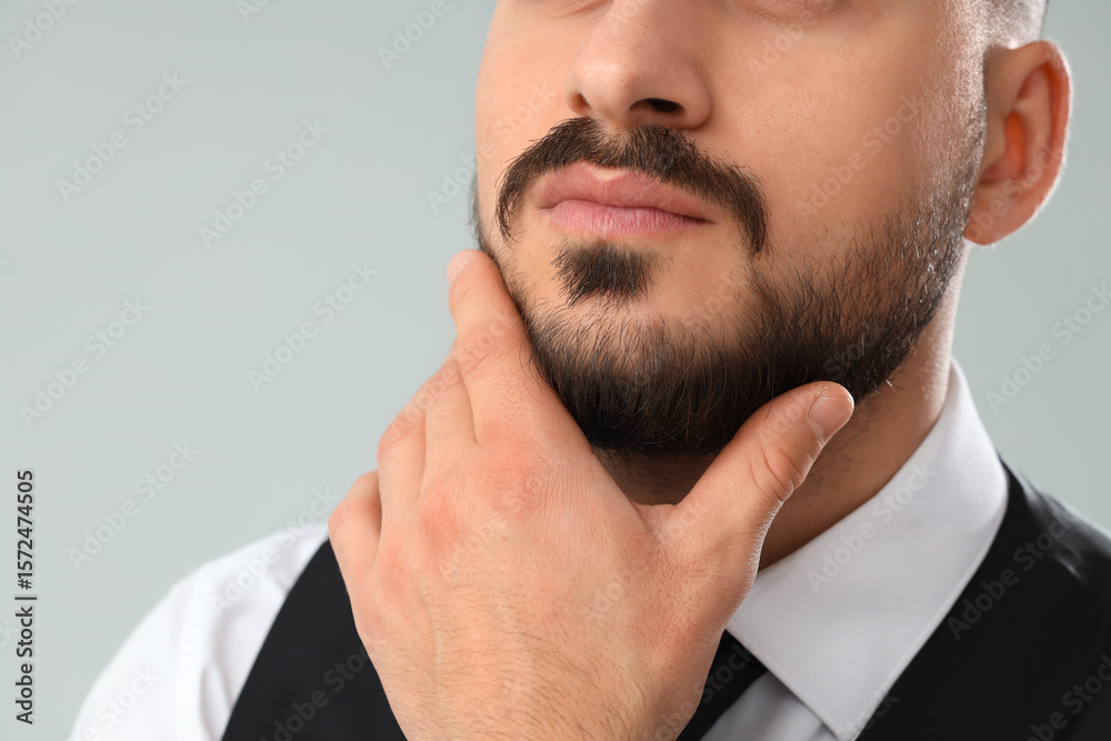 Obraz premium Handsome young bearded man on grey background, closeup