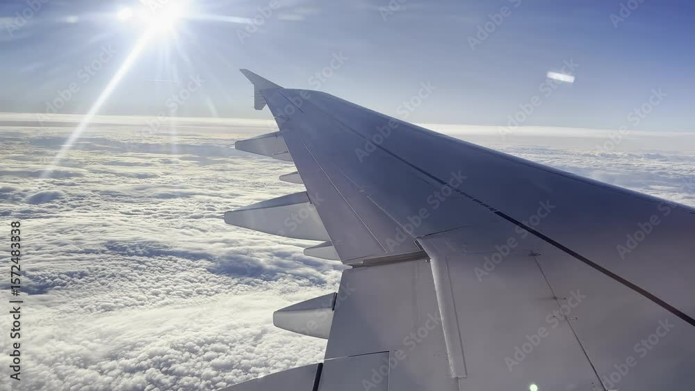 Blick aus einem Flugzeug über weitreichende Wolkenlandschaften mit einem blauen Himmel im Hintergrund