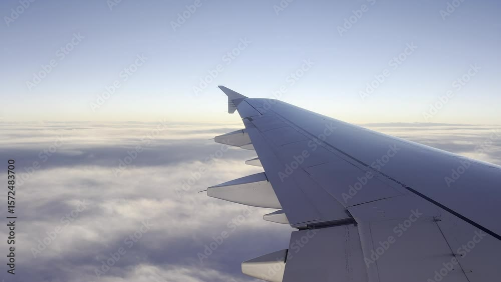 Blick aus einem Flugzeug über weitreichende Wolkenlandschaften mit einem blauen Himmel im Hintergrund