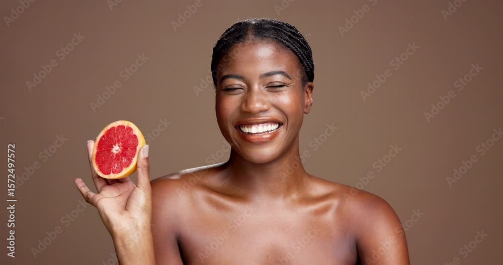 Laugh, face or happy black woman with grapefruit for brightening, beauty or space. Brown background, smile or African model in studio with tropical citrus for healthy glow, vitamin c and skincare