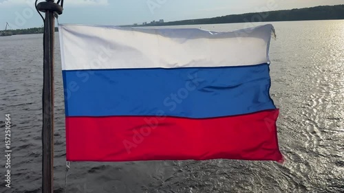 Russian tricolor flag proudly waves at the stern of the ship, fluttering in the wind during voyage.