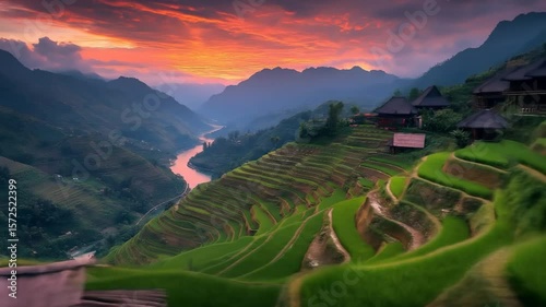 Aerial View of Lush Green Rice Terraces and Winding River in Mountainous Valley Under Dramatic Sunset Sky-Footage
