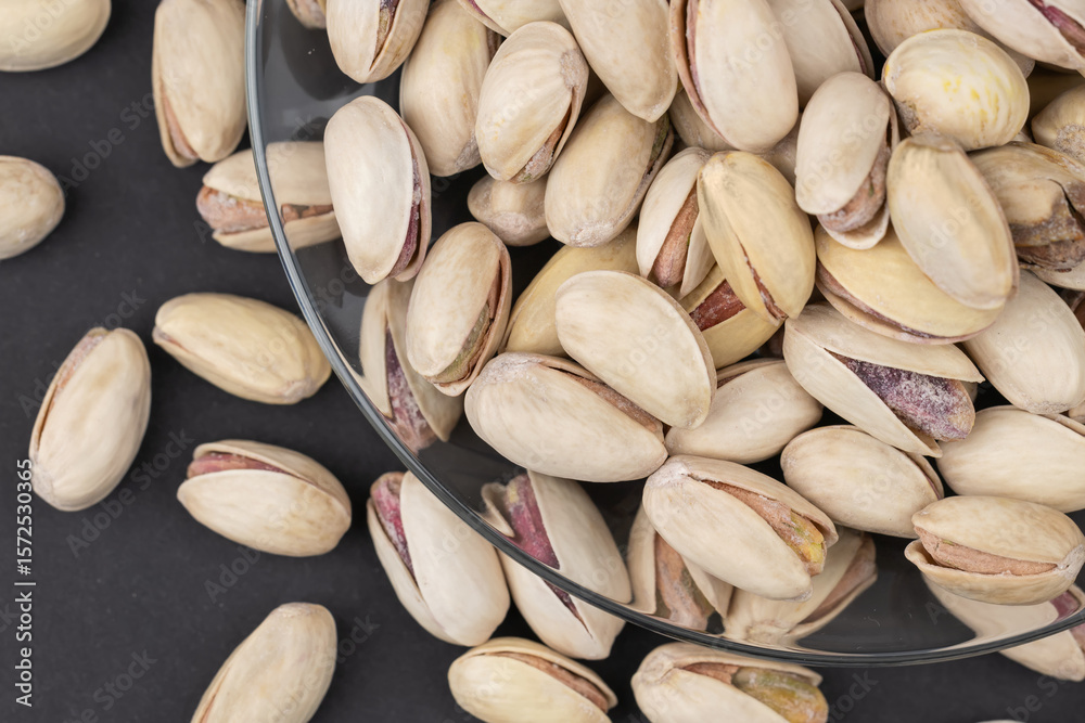 Fototapeta premium Salted Pistachios for Beer, Macro, on black Background of a Beer Snack of Salted Pistachio Nuts.