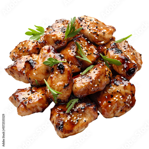 A pile of glazed chicken pieces with sesame seeds and green garnish on top