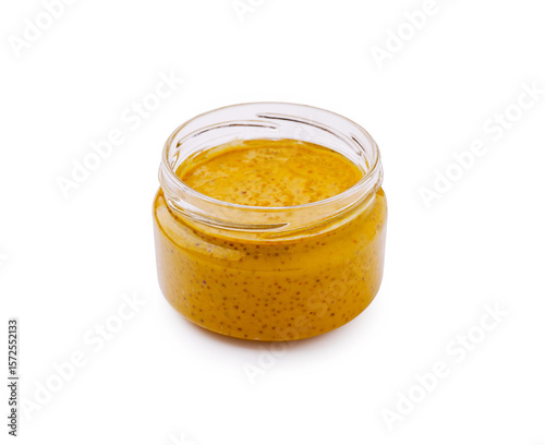 Homemade mustard in a clear glass jar on white background