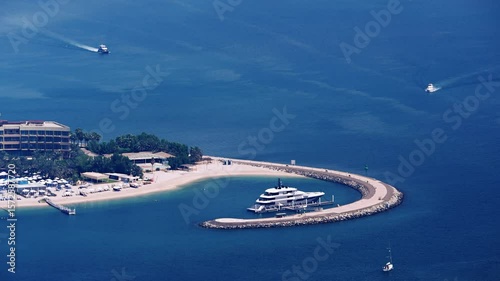 Luxury yacht anchored near private beach resort with sunny seaside scenic view, no logos
