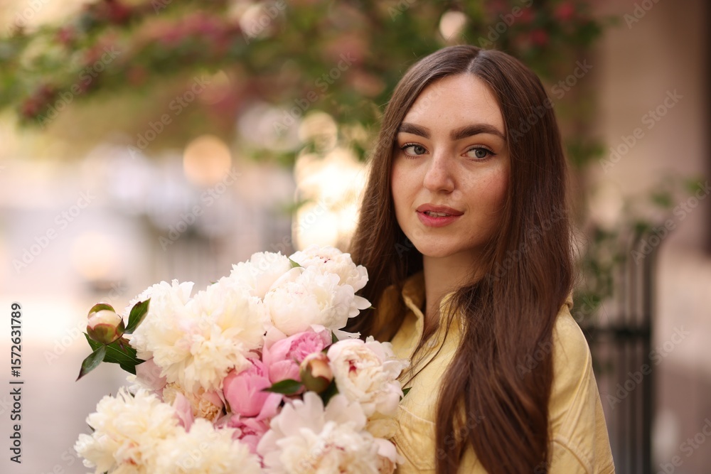 Fototapeta premium Woman with bouquet of beautiful peonies on city street