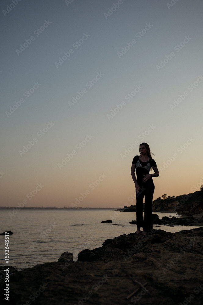 Fototapeta premium A person standing in front of a body of water
