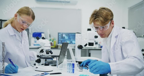 Scientists Conducting Laboratory Research with Microscopes and Laptops