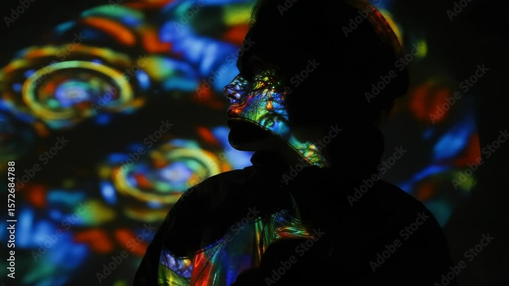 Silhouette of person with colorful, psychedelic light projections