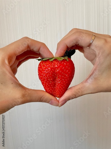 hands holding red heart By strawberry
