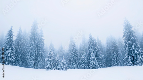 Magical winter forest at sunset with falling snowflakes, glowing orange light, snowy pine trees, serene landscape, Christmas atmosphere, peaceful nature, dreamy cold season background. Generative Ai