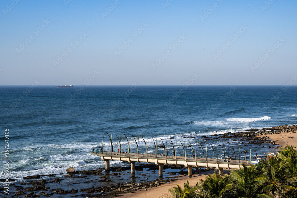 Fototapeta premium Umhlanga Beach with Whalebone Pier in South Africa on blue sky day