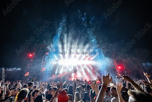 Obraz na płótnie Crowd enjoying live music concert with stage lights and confetti at night