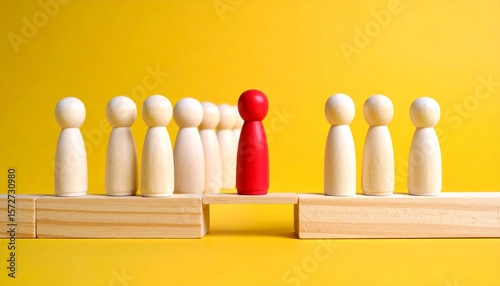 Red figurine standing among uniform wooden figures on yellow background, emphasizing individuality and contrast