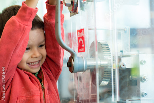 4 year old mixed race boy presses a souvenir penny at a local Sydney tourist attraction