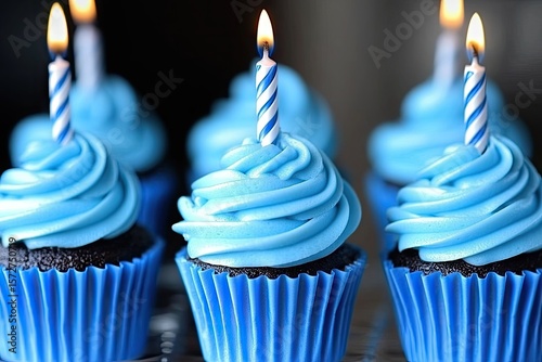 Birthday cupcakes with blue frosting and lit candles