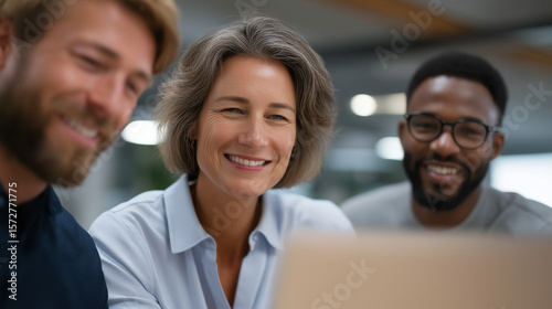 Diverse Team Collaborating Around Laptop in Modern Office