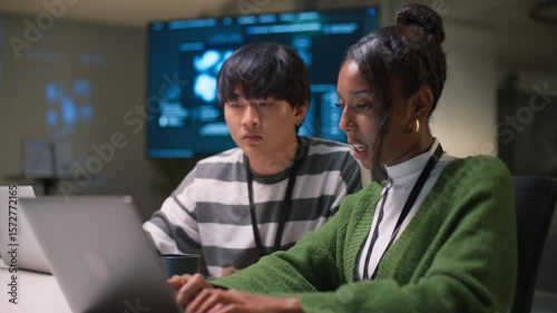 Diverse team of programmers engaged in intense discussion and collaboration at night office. Confident businesswoman leads strategic brainstorming in modern software development workplace.