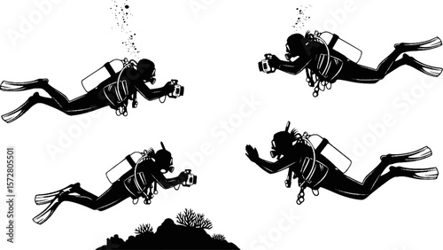 Silhouette of two scuba divers with cameras swimming underwater near coral and fish in the ocean water