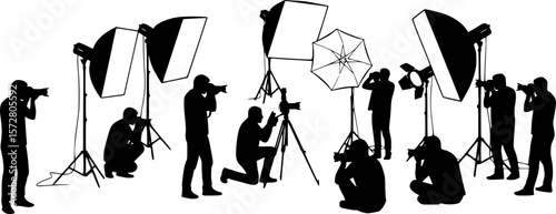 Silhouette of two photographers with studio lighting equipment in a photography session setting on white 