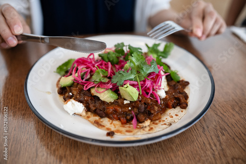 Flour Tortilla with Spicy black beans, fried eggs,  pickled cabbage, chipotle sour cream