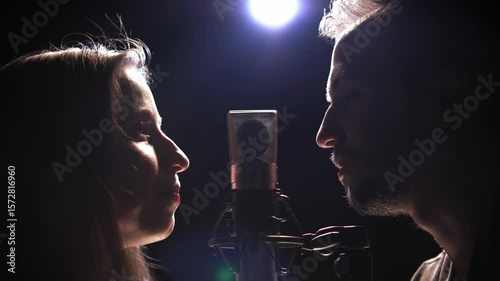 man and woman talking into a microphone face to face