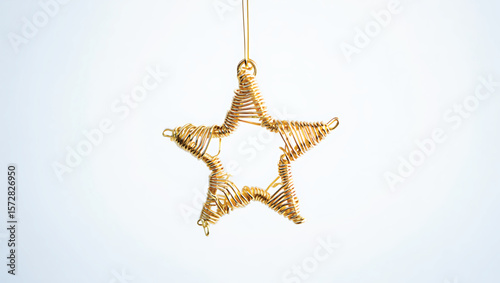 Golden wire star ornament hanging against a bright white background vector