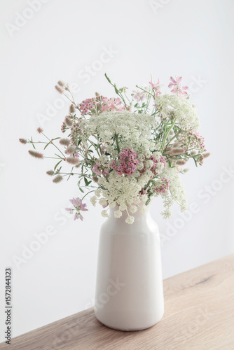 white and pink flowers in white vase on background white walll
