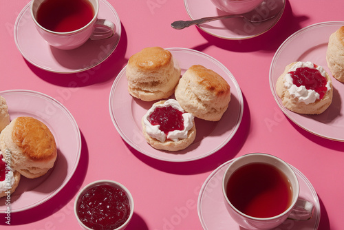scones with jam and cream in modern cool devonshire tea editorial on plain pink colour background surface