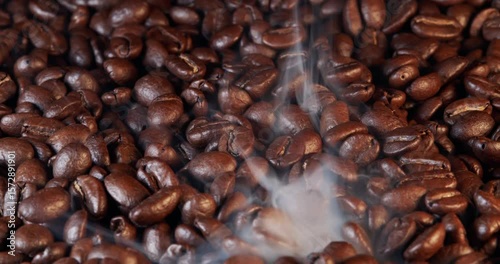 Close up of seeds of coffee. Fragrant coffee beans are roasted smoke comes from coffee beans.