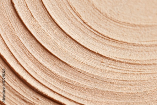 Close-Up of Beige Cosmetic Cream Texture with Concentric Layered Patterns.