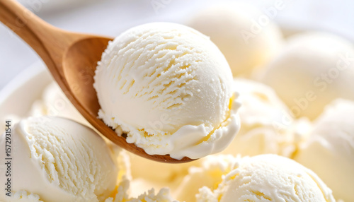 A close-up of a creamy vanilla ice cream scoop on a wooden spoon, perfect for summer treats.