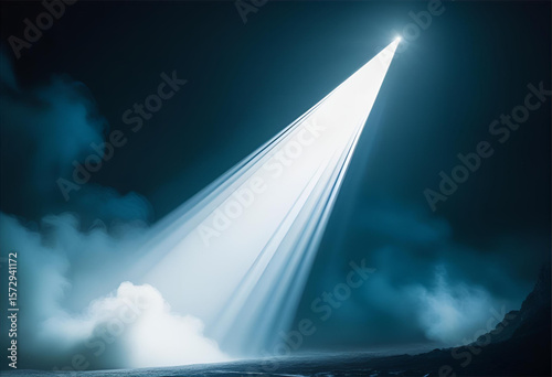 Bright light beam shining through dark night sky with fog and mist effect