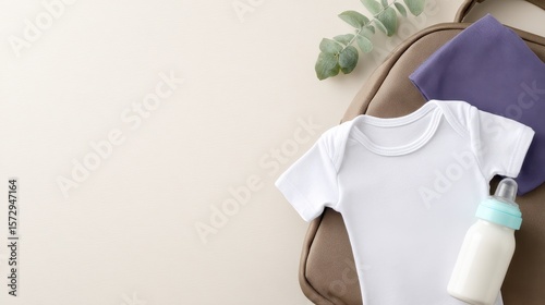 Baby essentials laid out on a neutral background, featuring a onesie, bottle, and cloth