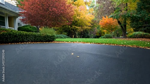 Residential asphalt driveway autumn season landscaping exterior view