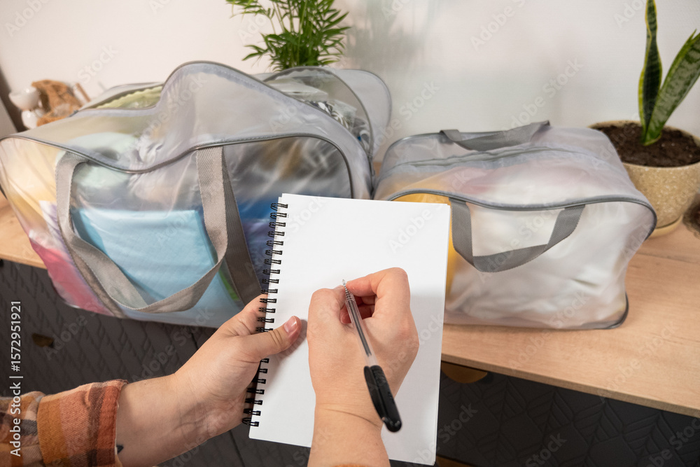 Fototapeta premium Pregnant woman at 9 months of pregnancy collects a bag in the hospital. Future mom preparing and planning clothes to the newborn baby