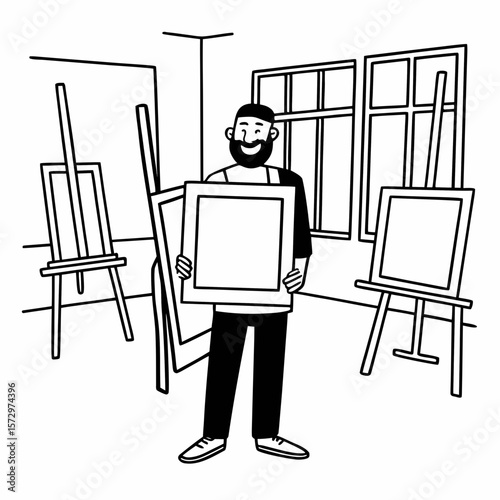 A smiling bearded man presenting a framed artwork in a bright artist's studio with easels and paintings.