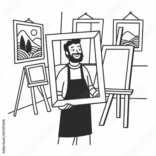 A smiling bearded man presenting a framed artwork in a bright artist's studio with easels and paintings.