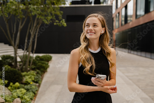 young pretty blond woman walkingoutside in street doing business