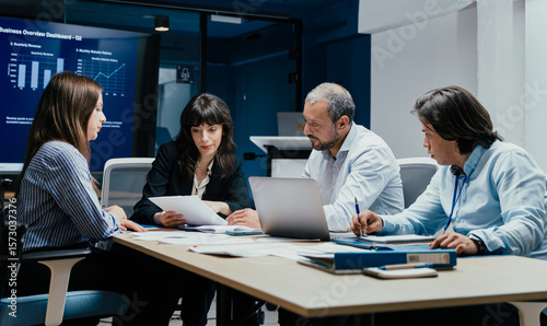 Business executives and assistants brainstorming investment risk evaluation in corporate boardroom