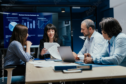 Business executives and assistants brainstorming investment risk evaluation in corporate boardroom