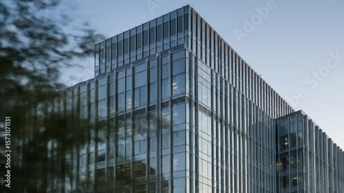 Wallpaper Mural Modern Glass Facade Building Exterior Under Blue Sky Showcasing Geometric Design and Urban Architecture Torontodigital.ca