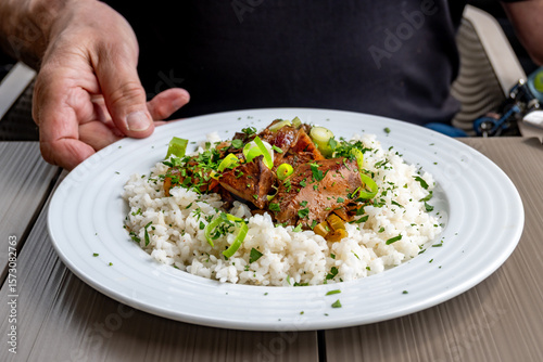Wallpaper Mural Roasted liver with rice, green onion shoot on white plate, hand and part of man. Torontodigital.ca