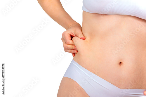 Woman pinching excess skin on her stomach. Concept of removing excess skin after weight loss, bariatric surgery or abdominoplasty.
