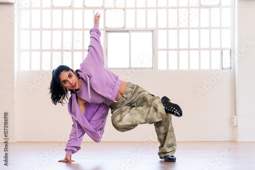 Hip-hop female dancer wearing colorful urban streetwear dancing