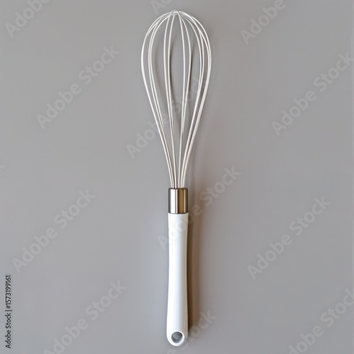 Positioned vertically on the left, the whisk has long, thin white wires and a pink handle.