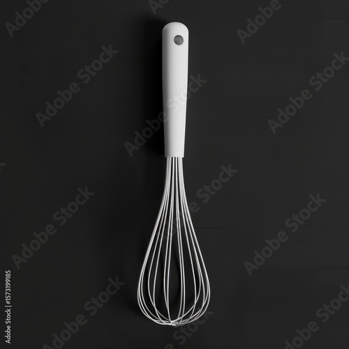 Positioned vertically on the left, the whisk has long, thin white wires and a pink handle.