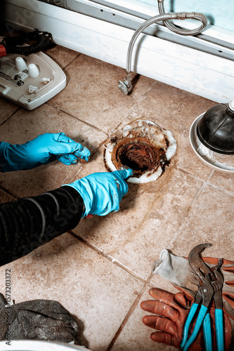 Close-up view of a Professional plumber replacing old wax ring seal before toilet installation, with copy space.